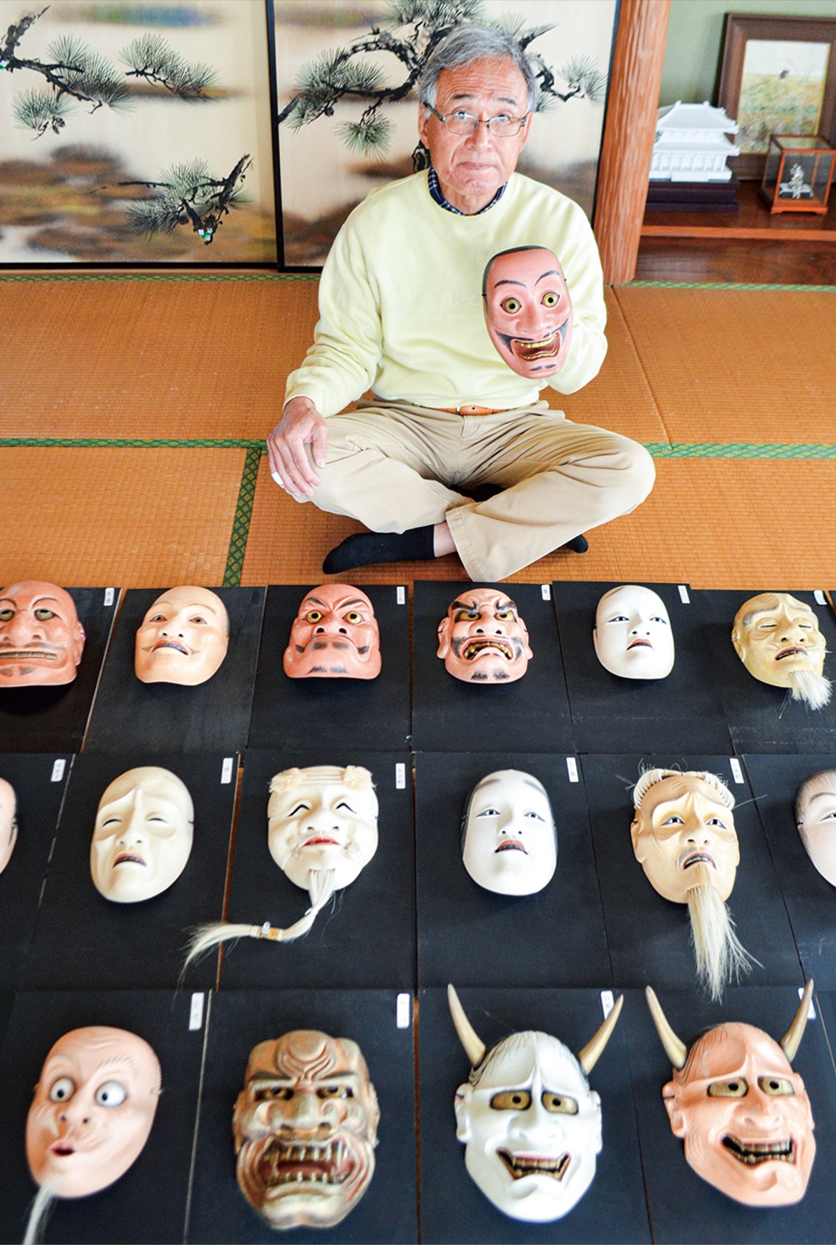 これまでに制作したさまざまな表情の能面を広げる横山さん=本人宅にて