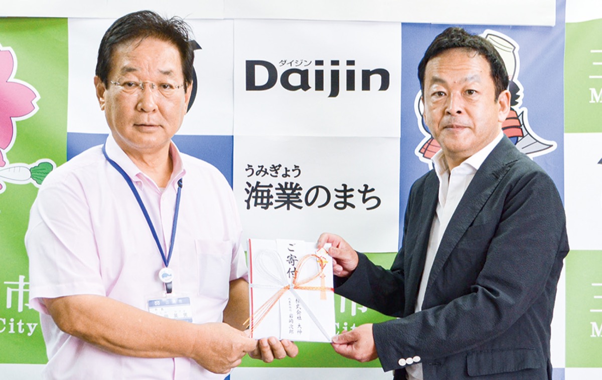 吉田市長(左)に目録を手渡す岩崎代表