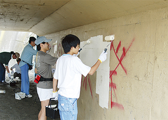 逗子海岸に通じる地下道に書かれた落書きを消すボランティア