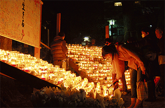 亀岡八幡宮では市民団体による手作りのろうそくが並べられ、日が暮れると次々に点灯。730個の鎮魂のともし火が揺らめき、参加者は祈りを捧げた