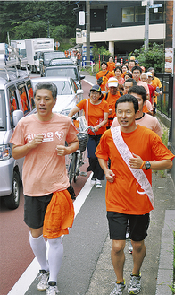 平井市長（写真右下）を先頭にオレンジ色のＴシャツを着て伴走する参加者ら（＝19日、桜山）