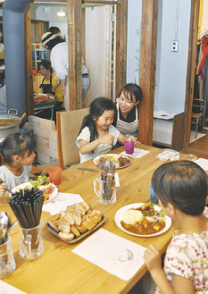 「こどもの食卓」でカレーを食べる子どもたちと清水さん
