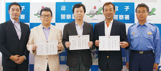吉田署長（右）が形山組合長（中央）らに任命状を手渡した