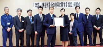 協定書を持つ桐ケ谷市長（中央左）、姜代表（同右）と関係者