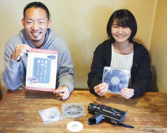 寄せられたフィルムを持つ高木さん（右）と、チラシを持つ新舘さん