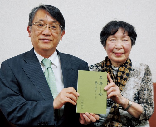 本を手にする本村さん（右）と森岡校長