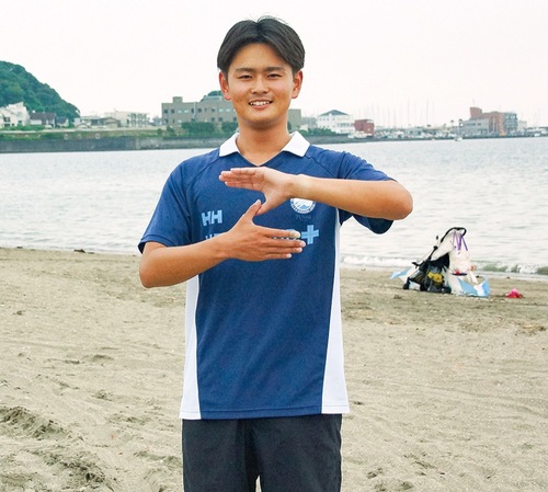 海をバックに逗子の「Ｚ」ポーズをとる大森さん