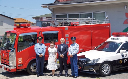 車両の前に立つ志原署長、森川さん、尾前社長、熊坂消防長（左から）
