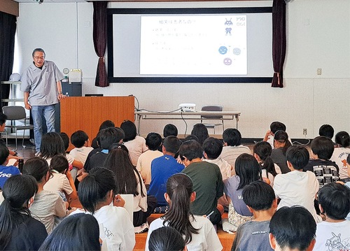 宮本教授（奥）の講義を聞く児童たち