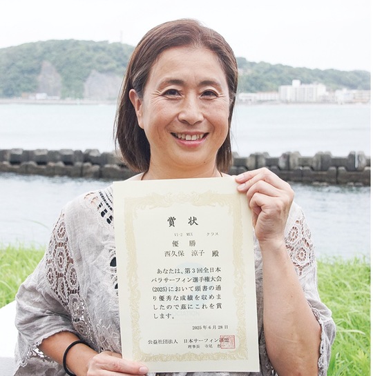 賞状を手に笑顔の西久保さん