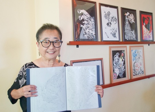 作品の前で下絵を持つＭＩＹＵＫＩさん