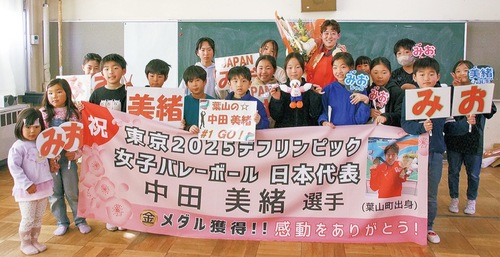 記念写真に収まる中田さんと児童