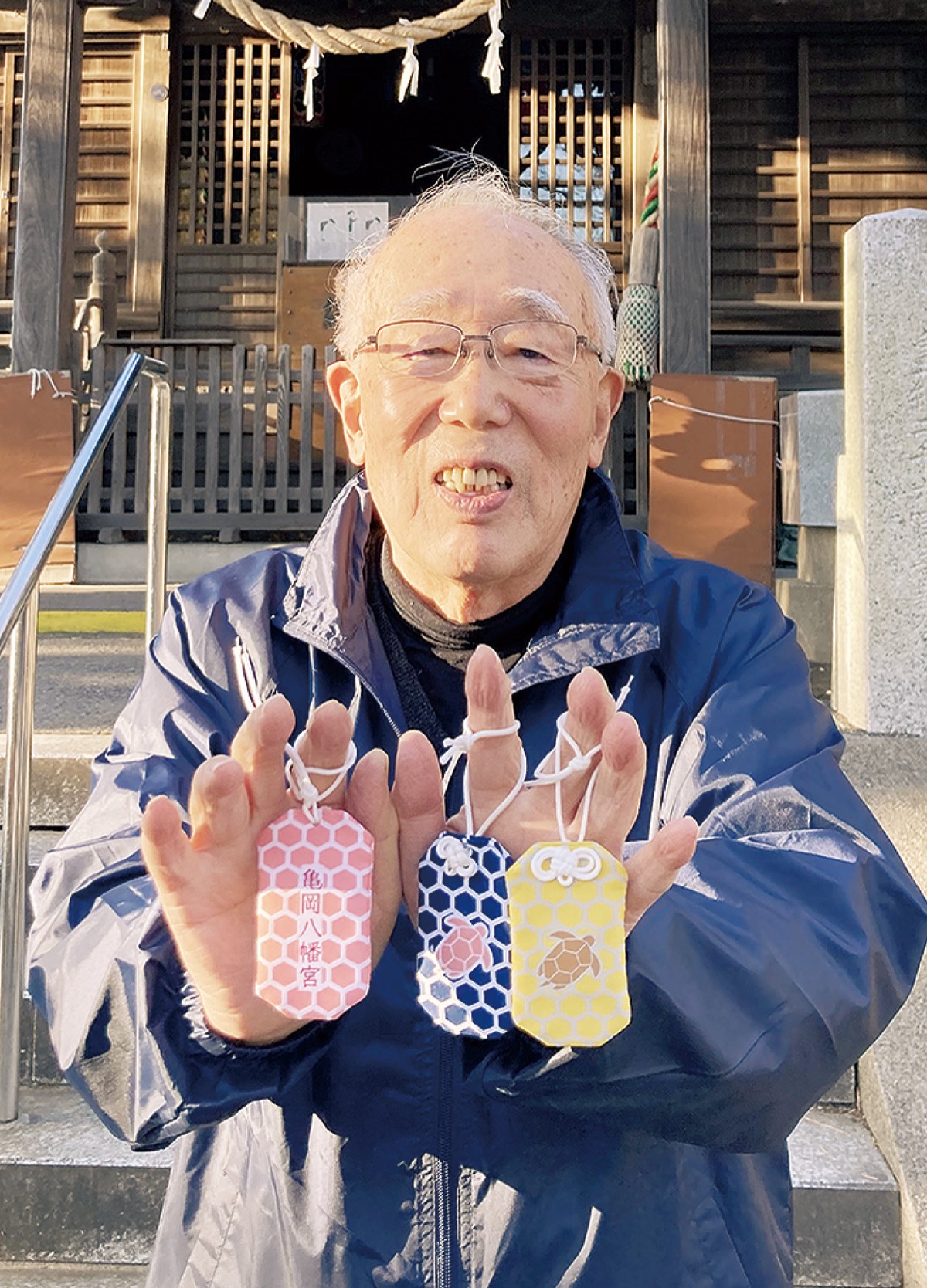 お守りを手にする総代の奥野さん