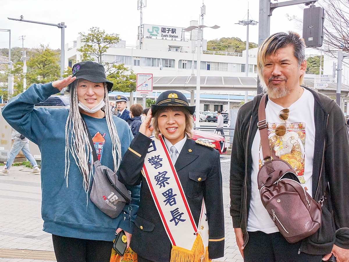 応援に駆けつけたレスラー仲間と敬礼する米山さん（中央）