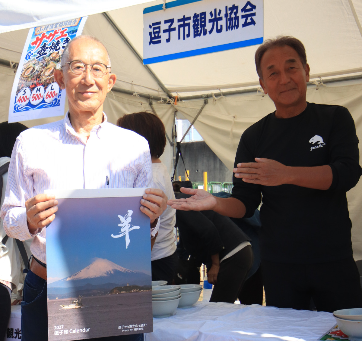 カレンダーを手に持つ礒貝さん(左)