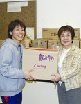 カーブス湘南海岸公園店長の稲葉里美さん（左）が、上條理事長に手渡した