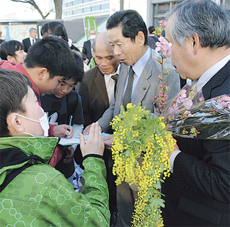 署名した人には河津桜や菜の花、ミモザが手渡された