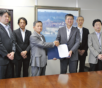 綾会長（中央左）と鈴木市長（中央右）が協定書を交わし、いざという時の連携に決意を新たにした
