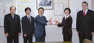 小澤社長（左から３人目）から吉田教育長に２００枚の入場券が手渡された