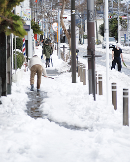 ８日の雪も残る中、雪かきをする住民ら