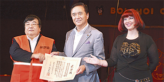 黒岩知事（中央）から感謝状を受け取る伊坂理事長（左）