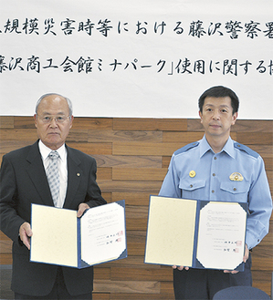 協定書を手にする田中会頭（左）と和智藤沢警察署長