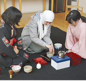 日本人学生から茶道を学び体験するアラブ人学生。作法やその意味について質問し、理解を深めた