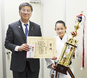 報告を受けた鈴木市長と優勝トロフィーを手にする高橋さん（右）