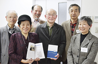 冊子を手にする宮田会長（右から３人目）と編集メンバー