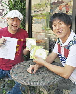 デモ版のＣＤと企画書を手に笑顔を見せるはっとさん（左）と鈴木会長