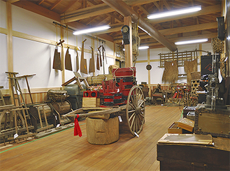 約20坪の木造建築の建物内には、荷車や鍬、のこぎり、祝い用の樽、お鉢などの昔の道具が100点以上並ぶ