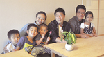 鎌倉から団地へ転居してきた菅原さん一家（左）と、スタッフ、遊びに来た団地の子ども