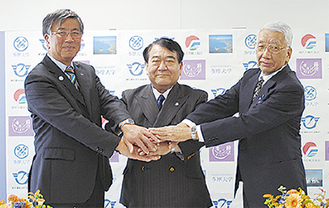 握手を交わす鈴木市長（左）と寺島学長（中）、二見会長