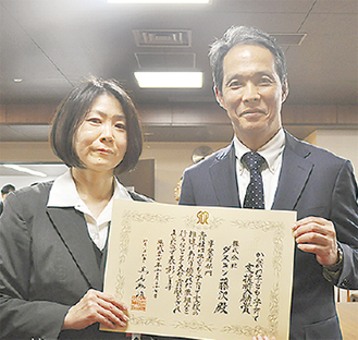 表彰状を手にする鈴木社長（右）とスタッフの清田さん