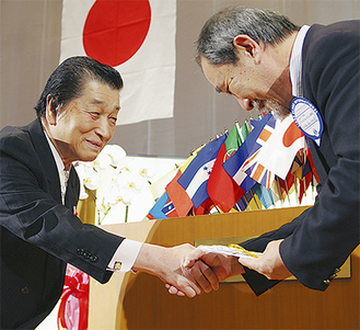 握手を交わす和田会長（左）