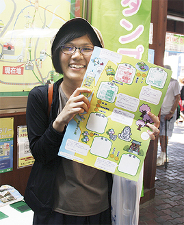 江ノ島駅で、専用の台紙を手にスタンプラリーを楽しむ渡士さん