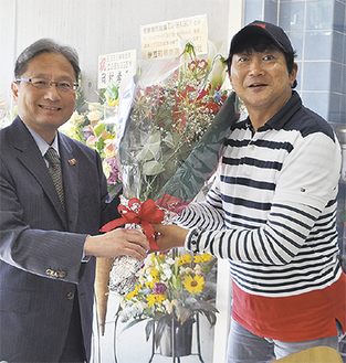 江ノ島電鉄の楢井社長（左）から花束が手渡された
