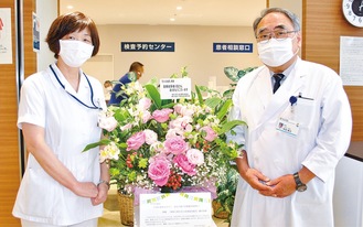 花を受け取った市民病院の常田康夫院長（右）と石原千賀子看護部長