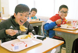 リクエスト給食「カツカレー」を食べ笑顔を見せる児童たち