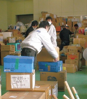 震災当時、石巻市の支援物資の受け入れ倉庫で作業するレディオ湘南のスタッフ（写真は提供）