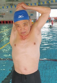 泳ぐ前に念入りにストレッチする下野さん（＝12日、秋葉台体育館プール）。5月の大会で、100mメドレーリレーの世界新記録樹立を目論んでいるという