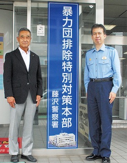 寄贈した看板と、増田会長（左）、小林署長