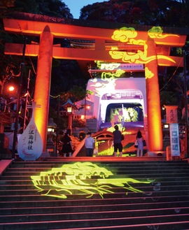 ライトアップされた江島神社に足を止める観光客