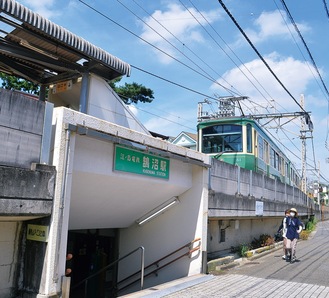 走行する車両と江ノ電鵠沼駅入口
