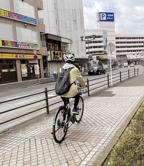 藤沢駅近くでヘルメットを着用する自転車利用者