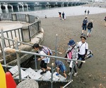 仮設階段を使って江の島に上陸する観光客