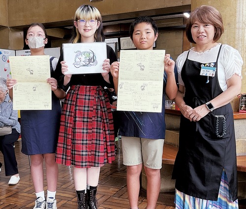 お祝いメッセージを手にするマイ・ミライメンバーと代表の細沼さん（右）