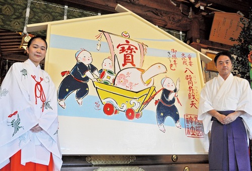 来年の干支｢ヘビ｣をモチーフに描かれた大絵馬と相原権宮司（右）ら