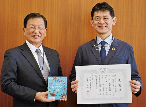 図鑑を手にする岩本教育長（左）、崎山館長