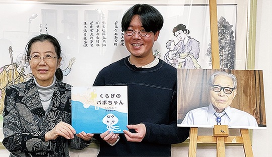 作品を手にするかこさんの家族